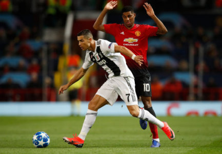 Juventus' Cristiano Ronaldo (left) and Manchester United's Marcus Rashford battle for the ball during the UEFA Champions League match at Old Trafford, Manchester.